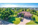 Aerial view of single-story home with tile roof, large yard, and paved driveway at 85 Spaniards Rd, Placida, FL 33946