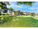 Single-story home with brown exterior, landscaping, and palm trees at 85 Spaniards Rd, Placida, FL 33946