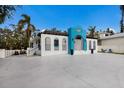 Bright white home with a unique blue fish accent and brick driveway at 1521 Siesta Dr, Sarasota, FL 34239