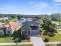 Beautiful home with a large lawn, lake view, and mature trees creating a private oasis at 1868 Scarlett Ave, North Port, FL 34289
