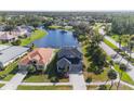 Aerial view of a well-maintained house near a pond in a picturesque neighborhood at 1868 Scarlett Ave, North Port, FL 34289