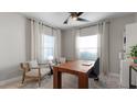 Home office featuring wood desk, two armchairs, and neutral decor at 2578 Wild Cherry Path, Sarasota, FL 34240