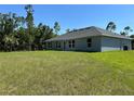 Home's backyard features well maintained lawn, and several windows providing natural light to the home at 3006 Chickasaw Ave, North Port, FL 34288