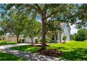 House exterior showcasing a well-maintained lawn, mature trees, and a paved driveway at 6227 Blue Runner Ct, Lakewood Ranch, FL 34202