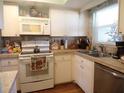 Galley kitchen with white cabinets, granite countertops, and stainless steel appliances at 670 Park Cir, Bradenton, FL 34207