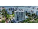 Aerial view of a modern highrise building with a pool and waterfront location at 111 Golden Gate Pt # 402, Sarasota, FL 34236
