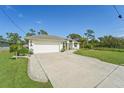 Single-story home with a white exterior, landscaping, and a two-car garage at 13380 Rayburn Ln, Port Charlotte, FL 33981