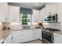 Modern kitchen with white cabinets, gray countertops, and stainless steel appliances at 16112 Isola Pl, Bradenton, FL 34211