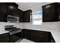 Stylish kitchen features stainless steel appliances and sleek dark cabinetry at 16112 Isola Pl, Bradenton, FL 34211