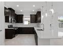 Modern kitchen with dark wood cabinets, stainless steel appliances, and a bright white countertop at 16112 Isola Pl, Bradenton, FL 34211