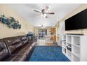 Living room with leather sofa, blue rug, and built-in shelving at 1742 Adams S Cir, Largo, FL 33771