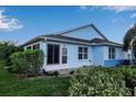 Rear view of a light blue house with a screened patio and lush landscaping at 3115 Live Oak Ln # 30, Palmetto, FL 34221