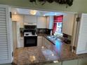 Kitchen with granite countertops and black appliances at 3500 El Conquistador Pkwy # 331, Bradenton, FL 34210