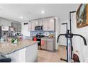 Modern kitchen with gray cabinets, granite countertops, and stainless steel appliances at 5058 Granite Dust Pl, Palmetto, FL 34221