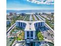 Aerial view showing condo building near beach, with pool and tennis courts at 5855 Midnight Pass Rd # 404, Sarasota, FL 34242