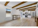 Modern kitchen with white cabinets, marble backsplash, and exposed wooden beams at 1305 11Th W Ave, Bradenton, FL 34205