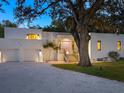 Modern white house with a pink door, two-car garage, and landscaped yard at 1331 Quail Dr, Sarasota, FL 34231