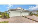 Two-car garage, paver driveway, and landscaping at 16223 San Donato Pl, Bradenton, FL 34211