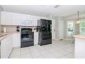 Kitchen with black appliances and white cabinets at 2467 E Del Webb Blvd, Sun City Center, FL 33573