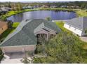 Stunning aerial view of home with a green roof and lake view in a lush community at 2603 River Woods Dr, Parrish, FL 34219