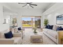 Bright living room featuring modern furniture, neutral decor, a ceiling fan, and sliding glass doors overlooking the water at 2603 River Woods Dr, Parrish, FL 34219