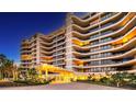 Elegant building exterior with landscaped grounds and nighttime lighting at 415 L Ambiance Dr # C703, Longboat Key, FL 34228