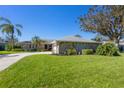 Single-story home with stone exterior, landscaping, and a circular driveway at 5666 Beneva Woods Cir, Sarasota, FL 34233