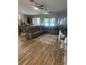 Open living room with sectional sofa, ceiling fans, and wood flooring at 2271 50Th Street E Cir, Palmetto, FL 34221