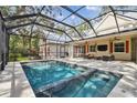 Screened-in pool and spa with tiled deck at 6008 Hammock Woods Dr, Odessa, FL 33556