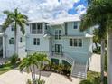 Two story home with light teal exterior and palm trees at 741 Shakett Creek Dr, Nokomis, FL 34275