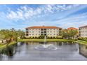 Three-story condo building with water fountain and lush landscaping at 980 Cooper St # 302, Venice, FL 34285
