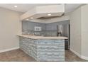 Modern kitchen with gray cabinets, quartz countertops, and stainless steel appliances at 10550 Old Grove Cir, Bradenton, FL 34212