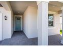 Inviting front entry with a teal door and brick paver walkway at 32015 Cannon Rush Dr, San Antonio, FL 33576