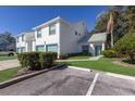 Condo with teal accents, attached garage, and a manicured lawn at 6591 Fairway Gardens Dr # 2-102, Bradenton, FL 34203
