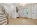 Bright entryway with light wood floors, staircase, and a white cabinet at 2492 S Milmar Dr, Sarasota, FL 34237