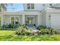 Front view of a light gray two-story house with a gray door and landscaped yard at 2492 S Milmar Dr, Sarasota, FL 34237