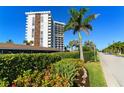 Exterior of the building with landscaping, showing the street and nearby palm trees at 1 Benjamin Franklin Dr # 121, Sarasota, FL 34236