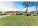 Single-story home with a yellow exterior and lush lawn at 5663 Country Lakes Dr, Sarasota, FL 34243