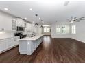 Open kitchen with island, white cabinets, and dark hardwood floors at 225 Daylily Blvd, Nokomis, FL 34275