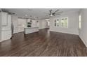 Open kitchen with island, white cabinets, and dark hardwood floors at 225 Daylily Blvd, Nokomis, FL 34275