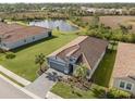 Aerial view of a single story home with a lake view in a residential community at 225 Daylily Blvd, Nokomis, FL 34275