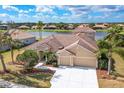 Two-story house with lake view, manicured lawn, and three-car garage at 246 Petrel Trl, Bradenton, FL 34212