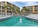 Community pool with surrounding lounge chairs at 3532 Lake Bayshore Dr # K117, Bradenton, FL 34205