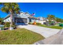 Curb appeal with palm trees, driveway, and a spacious front yard at 7505 W Lenox Cir, Punta Gorda, FL 33950