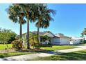 Single-story home with palm trees and well-manicured lawn at 818 Oak Pond Dr, Osprey, FL 34229