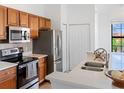 Modern kitchen featuring stainless steel appliances and wood cabinetry at 8377 38Th Street E Cir # 308, Sarasota, FL 34243