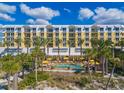 Building exterior featuring a pool and palm trees at 915 Seaside Dr # 407, Sarasota, FL 34242