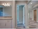 Bathroom vanity with granite countertop, white cabinets, and a view into the hallway at 160 Apollo Dr, Rotonda West, FL 33947