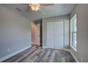 Neutral bedroom featuring a window and closet, and gray wood-look flooring at 160 Apollo Dr, Rotonda West, FL 33947