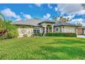 Green house with lush landscaping and a two-car garage at 17040 Kellog Ave, Port Charlotte, FL 33954